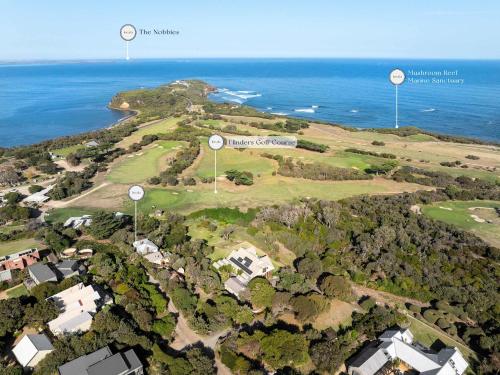 een luchtfoto van een golfterrein met twee windmolens bij Cleversley Cottage - Ocean Views Pets Golf in Flinders