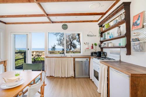 een keuken met een tafel en een groot raam bij Cleversley Cottage - Ocean Views Pets Golf in Flinders