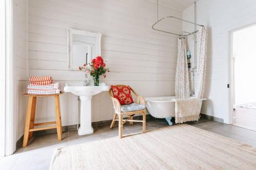 a bathroom with a sink and a tub and a mirror at The Sunday School - Timeless Cottage Wine Region in Red Hill