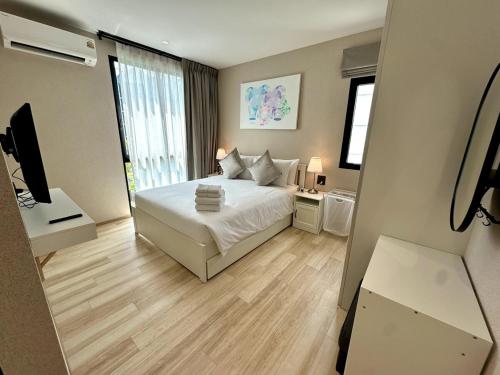 a bedroom with a bed and a television in it at Beatiful titlhalo apartment in Nai Yang Beach
