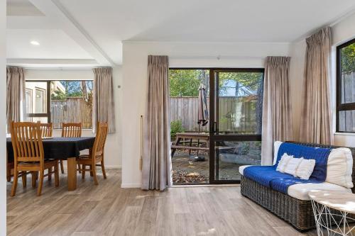 a living room with a table and a dining room at The Tuis Nest in Taupo