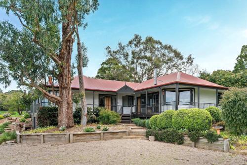 a house with a red roof and trees at Coast n' Country - Bay Views Pool Games in Red Hill South