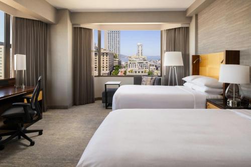 a hotel room with two beds and a desk at San Francisco Marriott Union Square in San Francisco