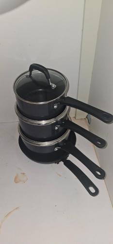 a black pan and tongs sitting on a counter at Discovery Beach Apartments in Aguada