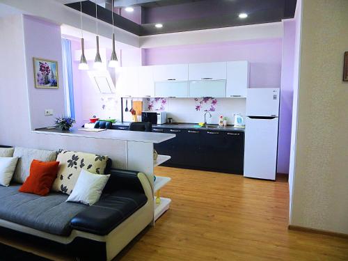 a living room with a couch and a kitchen at Bishkek Flatlux Apartments in Bishkek