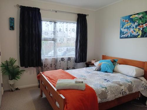 a bedroom with a bed and a window at Three Doors Whole 3bdr Home Central Motueka in Motueka
