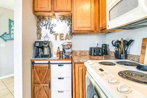 a kitchen with wooden cabinets and a stove at Table Rock Lake Retreat Steps to Water and Pools! in Kimberling City