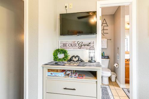 a bathroom with a tv on a wall at Table Rock Lake Retreat Steps to Water and Pools! in Kimberling City