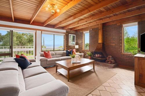 Una sala de estar con un sofá y una chimenea. en Bayview Retro - Garden Patio Games Beach, en Mount Martha