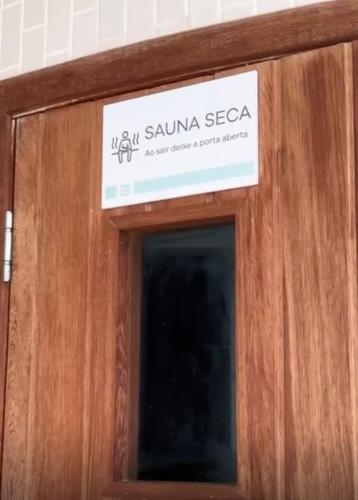 ein Schild an der Tür eines Hotels in der Unterkunft Prainha Sand Beach Arraial do Cabo in Arraial do Cabo