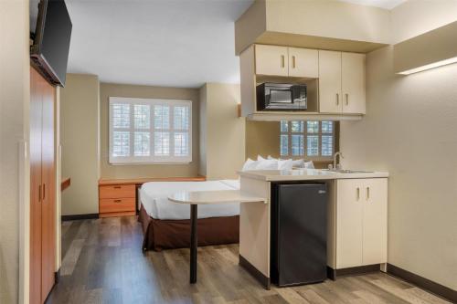 a small room with a bed and a kitchen at SureStay by Best Western Sacramento South Natomas in Sacramento