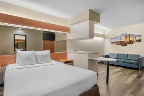 a hotel room with a bed and a kitchen at SureStay by Best Western Sacramento South Natomas in Sacramento