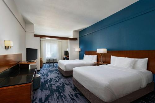 a hotel room with two beds and a blue wall at Fairfield Inn & Suites by Marriott Fredericksburg Texas in Fredericksburg