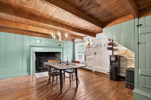 a dining room with a table and a fireplace at Historic 1802 Forge Home by North River & Trails in Capon Bridge
