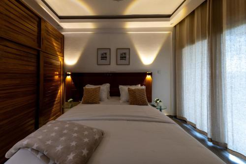 a bedroom with a large bed with a wooden headboard at Julianah appart in Douala