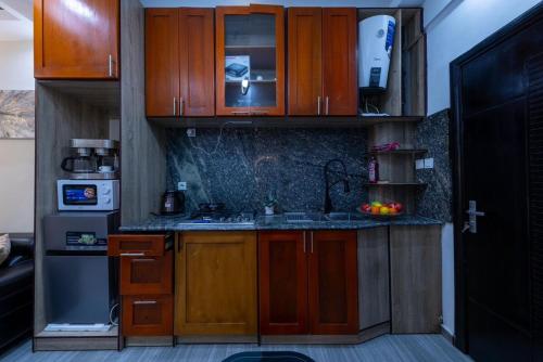 a small kitchen with wooden cabinets and a sink at Julianah appart in Douala