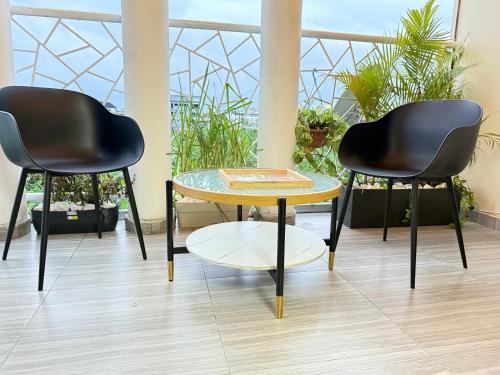 two chairs and a table in a room with plants at Julianah appart in Douala