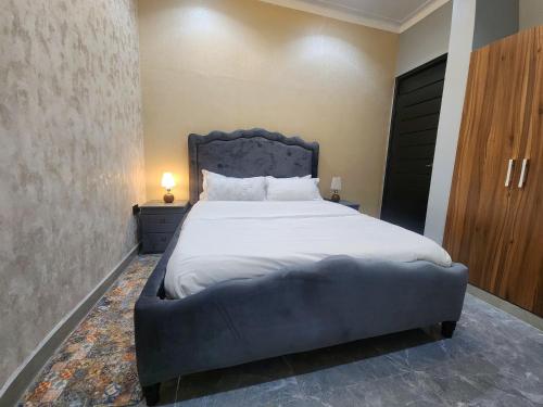 a bedroom with a large bed with a blue headboard at Muyenga Tank Hill Apartments in Kampala