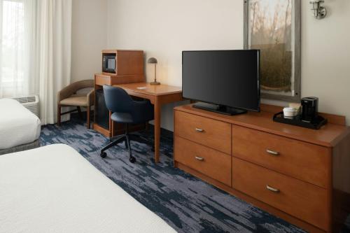 a hotel room with a desk and a television on a dresser at Fairfield Inn & Suites Santa Maria in Santa Maria