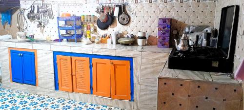 a kitchen with orange and blue doors on a counter at Oasis travel in Ksar Tazouga