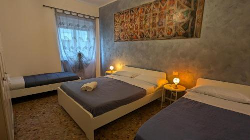 a bedroom with two beds and a window at Marconi Rooms and Apartments in Verona