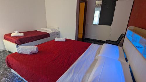 two beds in a room with red and blue sheets at Marconi Rooms and Apartments in Verona