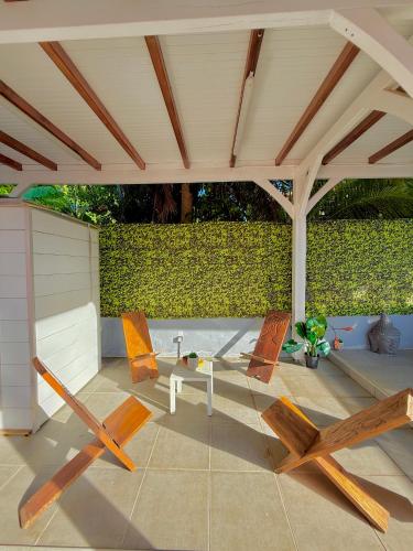 a patio with chairs and a table under a pavilion at Villa SAADA cosy avec piscine, jacuzzi et sauna in Le Vauclin