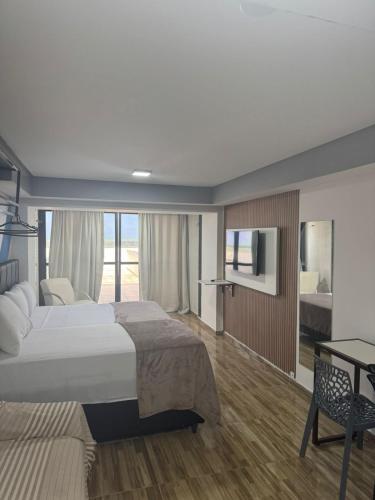 a hotel room with two beds and a television at Suite vista mar marinas cabo branco in João Pessoa