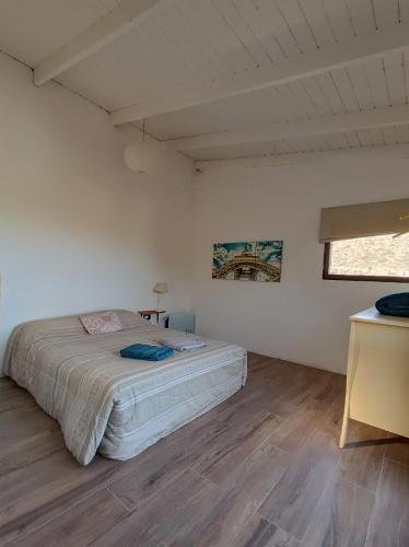a bedroom with a bed in a white room at Cabaña del Mirador 4 in Puerto Pirámides