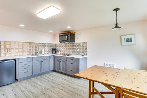 a kitchen with blue cabinets and a wooden table at Lake Whatcom House with Private Hot Tub and Dock in Bellingham