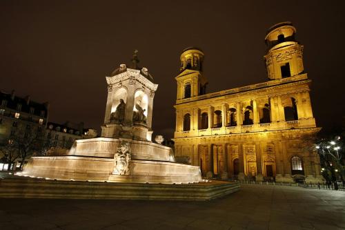 a large building with a statue in front of it at Hotel Clément in Paris