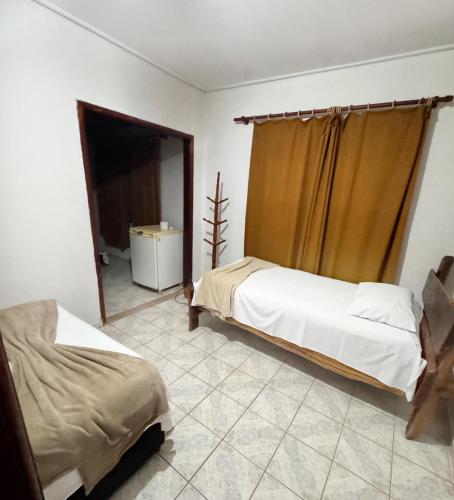 a bedroom with two beds and a window in it at Pousada JK in Pirenópolis