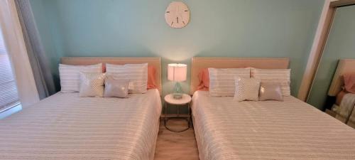 two beds sitting next to each other in a bedroom at Private Beach Access Pool & Hot Tub BBQ Pits Gulfview II #408 home in South Padre Island