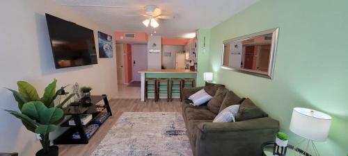 a living room with a couch and a kitchen at Private Beach Access Pool & Hot Tub BBQ Pits Gulfview II #408 home in South Padre Island