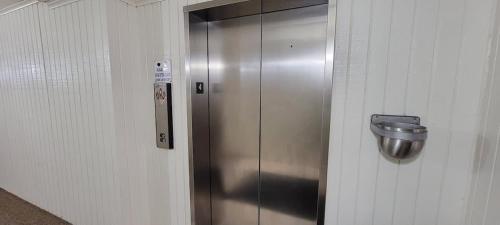 a metal elevator in a room with a trash can at Private Beach Access Pool & Hot Tub BBQ Pits Gulfview II #408 home in South Padre Island