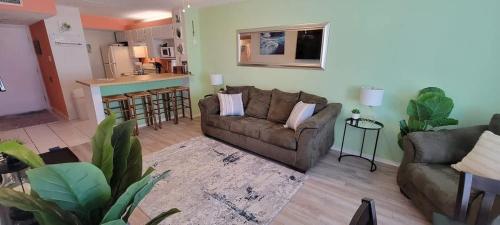 a living room with a couch and a kitchen at Private Beach Access Pool & Hot Tub BBQ Pits Gulfview II #408 home in South Padre Island
