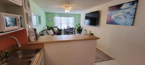 a kitchen and living room with a sink and a counter at Private Beach Access Pool & Hot Tub BBQ Pits Gulfview II #408 home in South Padre Island