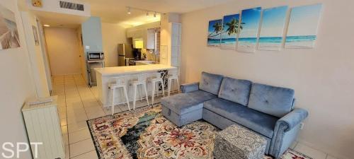 a living room with a blue couch and a kitchen at Beach Access Condo with Pool, Hot Tub Area & BBQ - Gulfview I - unit 213 in South Padre Island