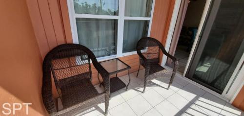 two chairs sitting on a porch next to a window at Beach Access Condo with Pool, Hot Tub Area & BBQ - Gulfview I - unit 213 in South Padre Island