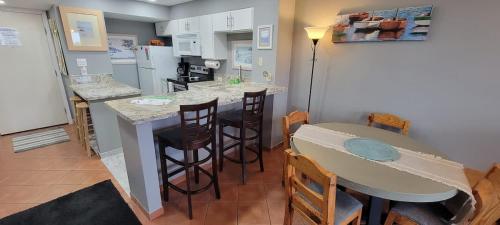 a kitchen with a table and chairs and a counter top at Great Family Condo with EZ Beach Access & SpaceX view Gulfview II #604 in South Padre Island