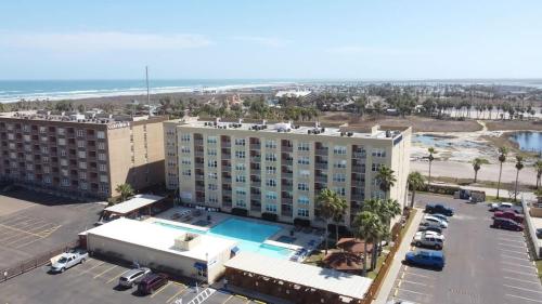 an aerial view of a hotel with a parking lot and the ocean at Great Family Condo with EZ Beach Access & SpaceX view Gulfview II #604 in South Padre Island