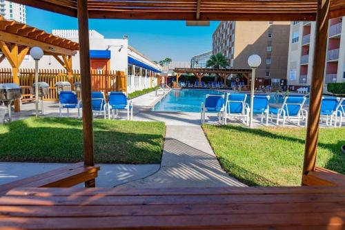 a view of the pool at a resort with blue chairs at Great Family Condo with EZ Beach Access & SpaceX view Gulfview II #604 in South Padre Island