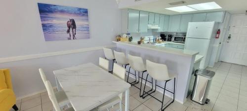 - une cuisine avec une table, des chaises et un comptoir dans l'établissement Surfside I #303 condo, à South Padre Island
