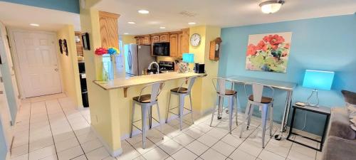 Una cocina con encimera y taburetes en una habitación. en Habitat #23 home, en South Padre Island