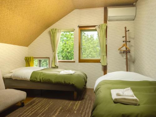 a bedroom with two beds and a window at Akane-yado in Nakafurano