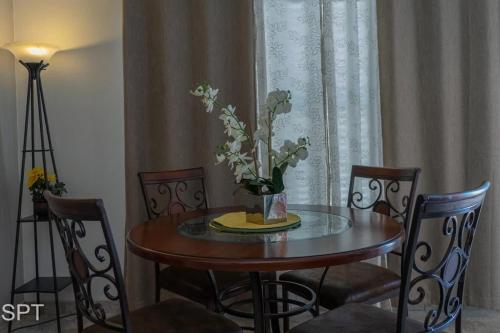 a dining room table with a vase of flowers on it at Luxe 1 Bedroom House with Pool - Gulfview II unit 410 in South Padre Island