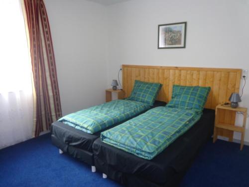 een slaapkamer met een bed met blauwe lakens en kussens bij Ferienhaus van Wijk in Obergude