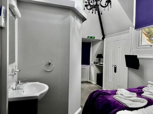 a white bathroom with a sink and a bed at Verve Hotel in Bedford