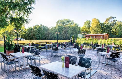 an outdoor patio with tables and chairs at Leonardo Hotel Köln Bonn Airport in Cologne