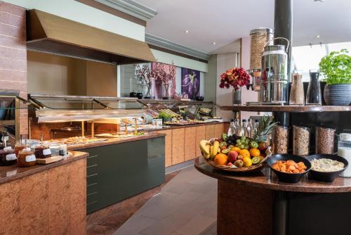 a kitchen with a bowl of fruit on a counter at Leonardo Hotel Köln Bonn Airport in Cologne